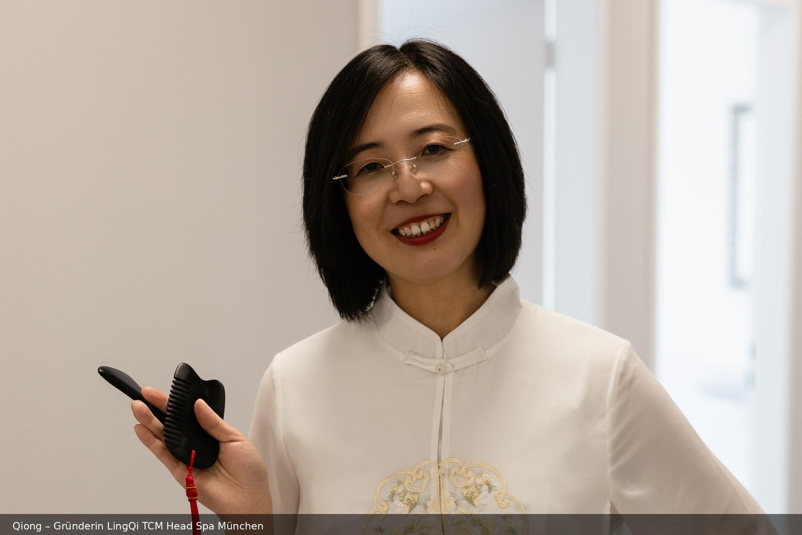 Qiong Qian-Morchner, Gründerin von LingQi TCM Head Spa München, mit einem Bojin-Schieferstein